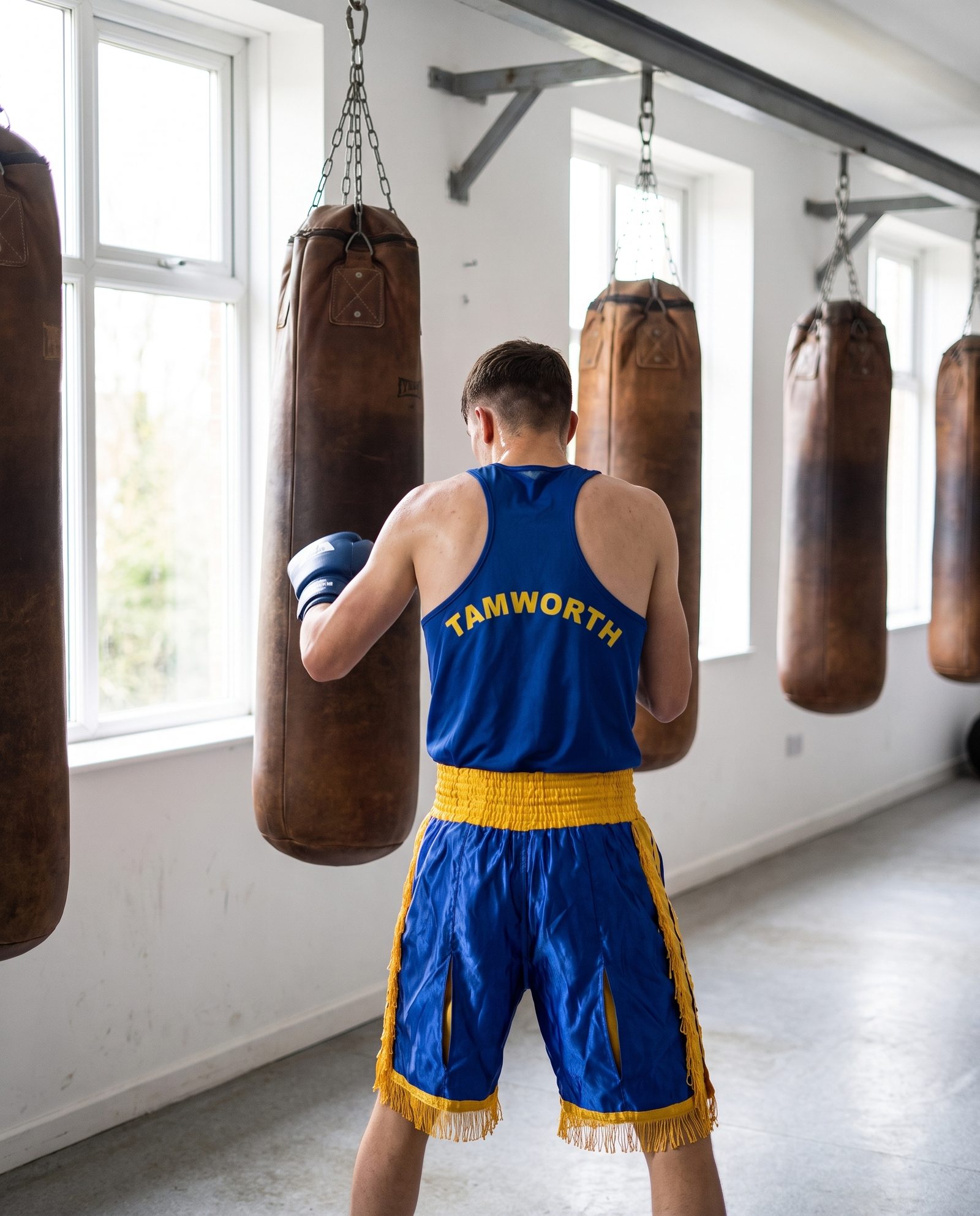 A young boxer in Tamworth kit working the heavy bag